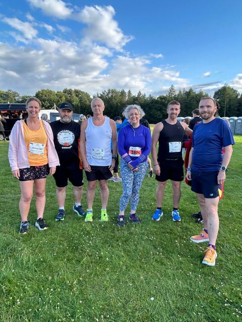 Group of runners posing in event shirts outdoors