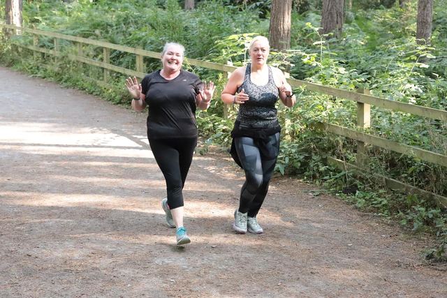 Two runners on a woodland path