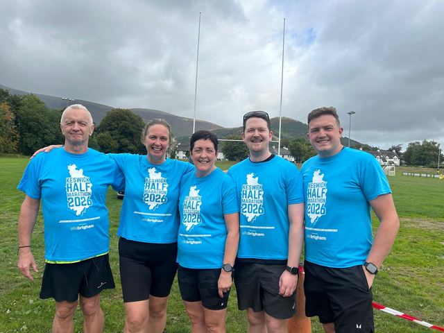 Group of runners in matching blue tops on a field