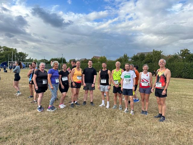Group of runners gathered on grass before a run